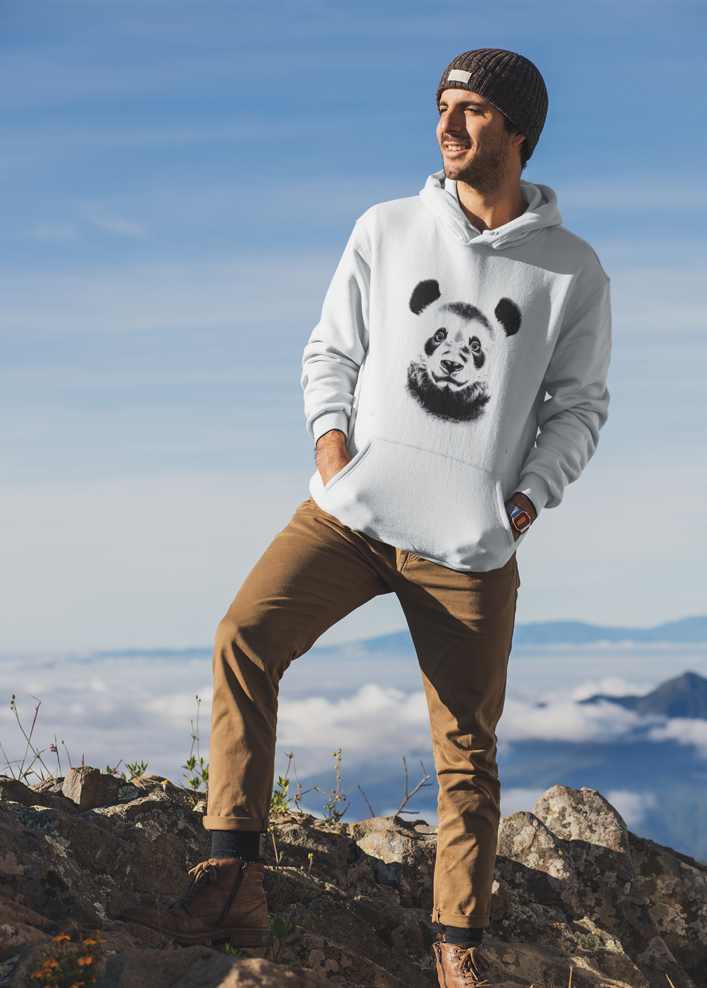 Man wearing a hoodie with a panda design on a mountain top